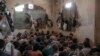 FILE -In this July 18, 2017, file photo, suspected Islamic State members sit inside a small room in a prison south of Mosul. 