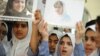 Students hold pictures of schoolgirl Malala Yousufzai, who was shot by the Taliban, during a tribute at the Pakistani Embassy in Abu Dhabi October 15, 2012. 