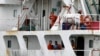 Crew members of the Panama-flagged cargo ship MV Asphalt Venture look out from the ship at the Kenyan Port of Mombasa, April 28, 2011. 