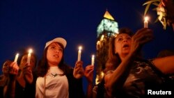 FILE - People attend a candlelight vigil for people missing after a boat carrying migrants from Tunisia sank off the southern Italian island of Lampedusa, September 2012, in Tunis September 10, 2012.