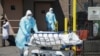 FILE - Bodies are moved to a refrigeration truck serving as a temporary morgue at Wyckoff Hospital in the Borough of Brooklyn on April 6, 2020 in New York.
