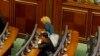 Smoke rises after Kosovo opposition lawmaker Donika Kada Bujupi ignites a tear-gas canister, disrupting Parliament's session for the third time in row, Pristina, Oct. 23, 2015.