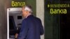A man uses an ATM cash point machine at a branch of the Bankia bank in Madrid, May 18, 2012.