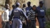 Police keep watch during the arrival of some of the 250 mine workers who were arrested when they had a shoot out with police, at a Garankuwa court outside Pretoria, South Africa, August 20, 2012. 