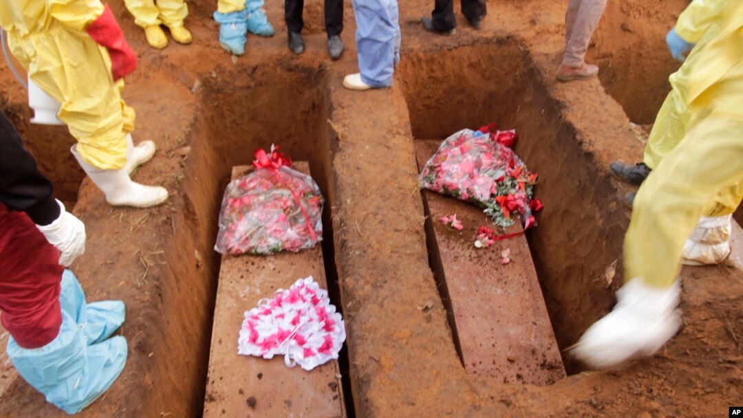 Volunteers bury coffins during a mass funeral for victims of heavy flooding and mudslides in a cemetery in Freetown, Sierra Leone, Aug. 17, 2017. 