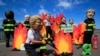 A man wearing a Trump mask, center, is joined by other 'world leaders' during a protest ahead of the G-7 summit in Biarritz, France, Aug. 23, 2019. 