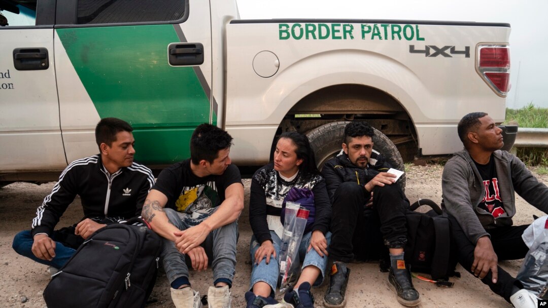 Migrantes colombianos que intentaban evadir a la Patrulla Fronteriza de EEUU esperan ser procesados cerca del puerto de entrada en Hidalgo, Texas, el 4 de mayo de 2023.