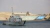 FILE - A cargo ship sails through the town of Ismailia, Egypt, March 30, 2021, as traffic resumed through the Suez Canal after it was blocked by a massive ship that had been stuck sideways for nearly a week.