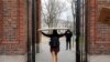 FILE - A student carries a box to her dorm at Harvard University, after the school said it would move to virtual instruction for graduate and undergraduate classes, in Cambridge, Massachusetts, March 10, 2020. 