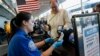 Transportation Security Administration officer Darby Finch checks boarding passes and identification at Logan International Airport in Boston, Dec. 23, 2018.