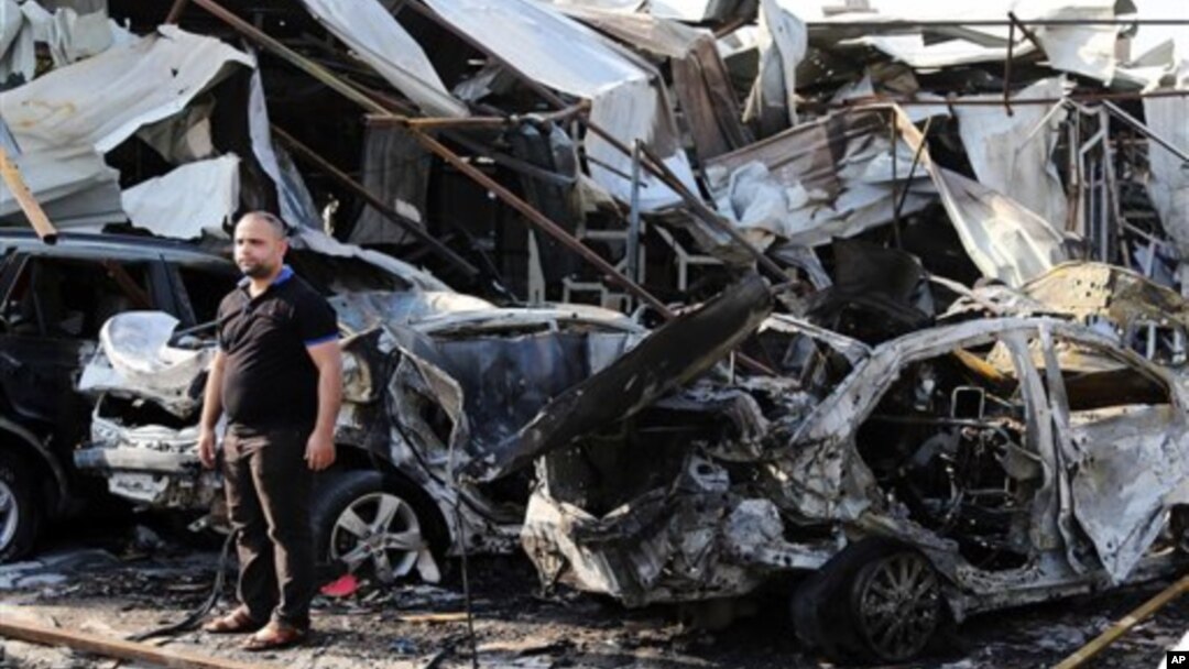 FILE - A man inspects site of car bomb explosion in Baghdad's eastern Mashtal neighborhood, Iraq, Nov. 17, 2014.