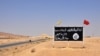 FILE - A general view taken on Aug. 13, 2017, shows an Islamic State (IS) group sign in the central Syrian town of Al-Sukhnah. Pro-government fighters cleared the area after taking control of the county's large desert area called the Badiya.