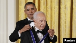 U.S. President Barack Obama presents the Presidential Medal of Freedom to Israeli President Shimon Peres in the East Room of the White House in Washington, June 13, 2012.