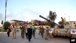 Fuerzas iraquíes y milicianos chiitas aliados celebran frente al concejo provincial en Tikrit, 130 kilometers al norte de Bagdad, Irak, el martes, 31 de marzo, de 2015.