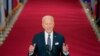 President Joe Biden holds up his face mask as he speaks about the COVID-19 pandemic during a prime-time address from the East Room of the White House, March 11, 2021.