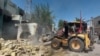 Protesters use a bulldozer to demolish offices of Shiite parties during ongoing anti-government protests in Nasiriyah, Iraq, Aug. 22, 2020. 
