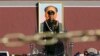 A Paramilitary soldier stands guard behind a chain as the giant portrait of the late Chinese Chairman Mao Zedong is seen in the background in Tiananmen square, Nov. 12, 2013.