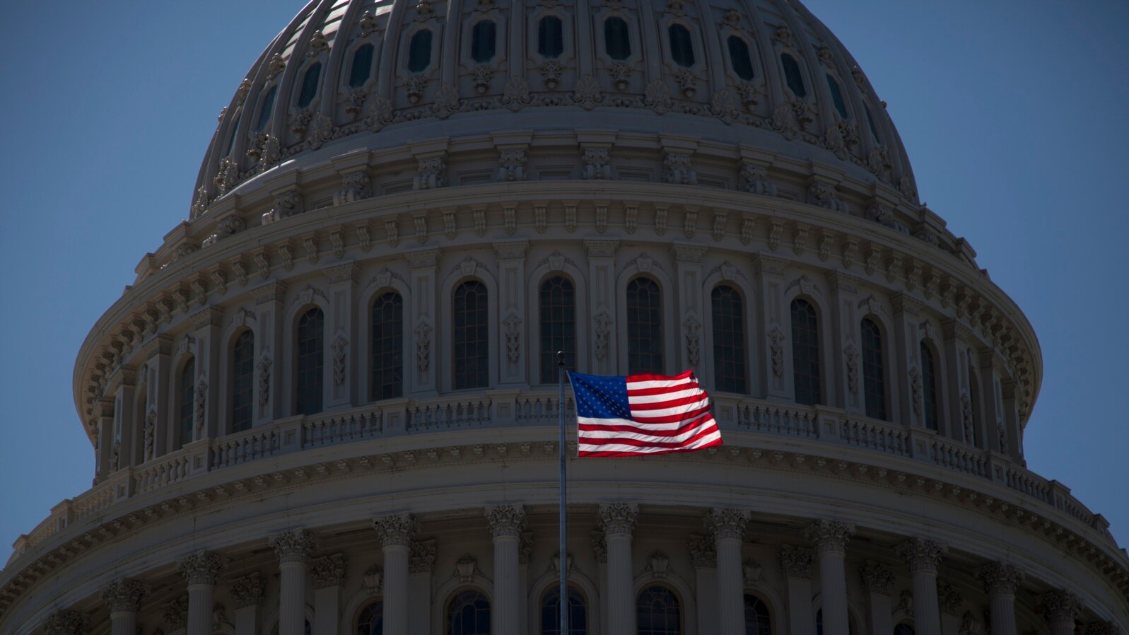 FILE - An American flag flies in front of the dome of the U.S. Capitol, July 26, 2011.