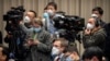 Journalists wearing face masks attend an official press conference about a virus outbreak at the State Council Information Office in Beijing, Jan. 26, 2020. 