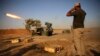 Shi'ite fighters from Mahde Army launch rockets during heavy fighting against Islamic state members, Bo Hassan village, northern Iraq, Sept. 12, 2014.