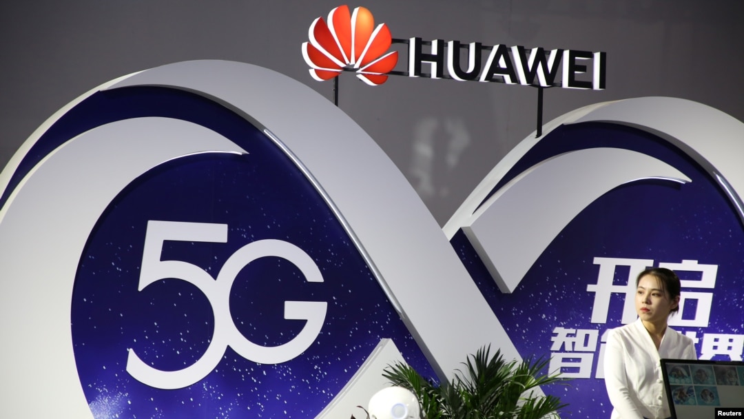 A woman stands at the booth of Huawei featuring 5G technology at the PT Expo in Beijing, China, Sept. 28, 2018.