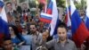 This photo from the Syrian news agency SANA shows Syrians in front of the Russian Embassy in Damascus expressing their thanks to Russia for its intervention, Oct. 13, 2015. Few Syrians who leave their country, however, are finding Russia to be a safe haven.