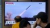 지난 25일 한국 서울역 이용객들이 북한 단거리 탄도미사일 발사 관련 TV 뉴스를 시청하고 있다. (자료사진)