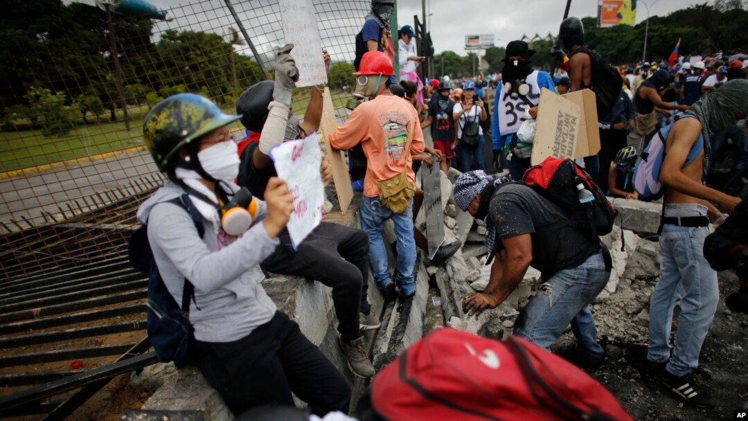 Manifestantes derribaron una cerca de la base aérea La Carlota durante una protesta en las afueras de Caracas, el sábado, 24 de junio de 2017.
