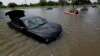 Domingo Molina paddles with his granddaughters down a flooded street in Houston, May 26, 2015. 