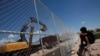 A child looks at U.S. workers building a section of the U.S.-Mexico border wall at Sunland Park, U.S. opposite the Mexican border city of Ciudad Juarez, Mexico, Aug. 26, 2016. Picture taken from the Mexico side of the U.S.-Mexico border. 