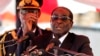 Zimbabwean President Robert Mugabe gestures as he addresses mourners gathered for the burial of Vice-President John Nkomo at National Heroes Acre, in Harare, Zimbabwe, January 21, 2013.