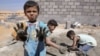 Syrian refugee children play with clay after workers end work at Al Zaatri refugee camp in the Jordanian city of Mafraq, near the border with Syria, September 2, 2012.