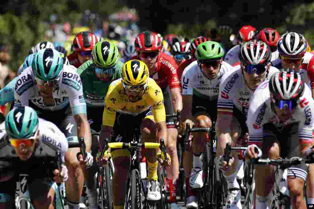 The pack rides with France's Julian Alaphilippe wearing the overall leader's yellow jersey during the tenth stage of the Tour de France cycling race over 217 kilometers (135 miles) with start in Saint-Flour and finish in Albi, France.