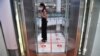 A woman stands in an elevator with markers on the floor for social distancing measures in a shopping mall amid concerns over the spread of the COVID-19 coronavirus in Bangkok, Thailand. 