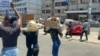 Cidadãos seguram cartazes com os dizeres “Este país é nosso” e “Juntos contra a corrupção” durante um protesto com buzinas em Maputo, capital de Moçambique. 21 novembro 2024